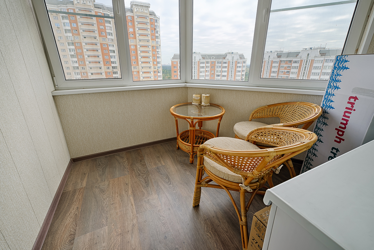 плетеные кресла и столик на балконе